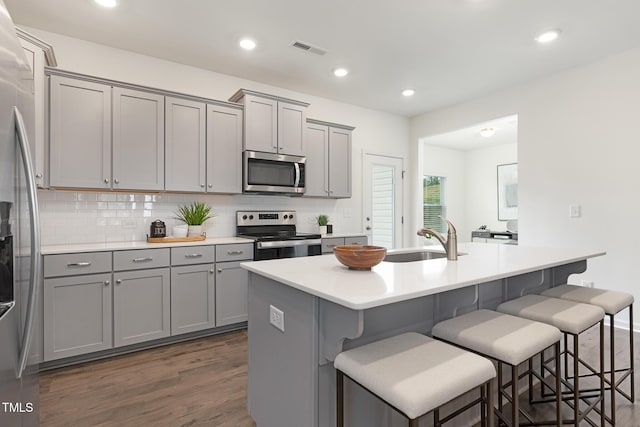 69 Curling Creek Dr Unit I286, Clayton, NC 27527 - kitchen with stainless steel appliances, gray cabinets, a sink, a kitchen breakfast bar, and backsplash