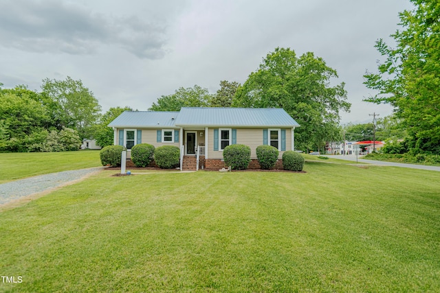 single story home with a front yard and metal roof