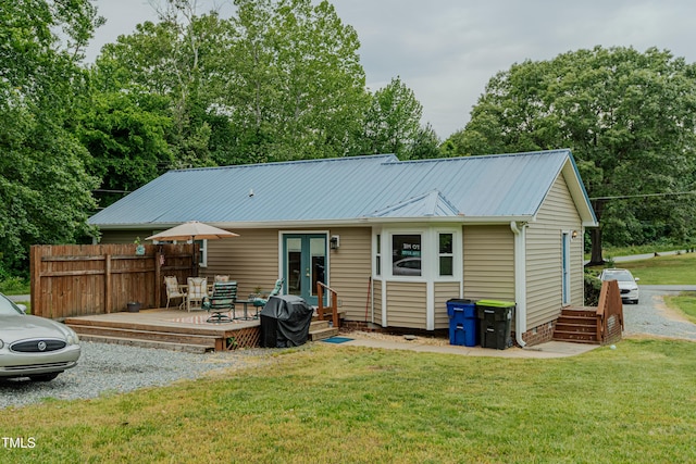 rear view of house featuring french doors, a deck, and metal roof