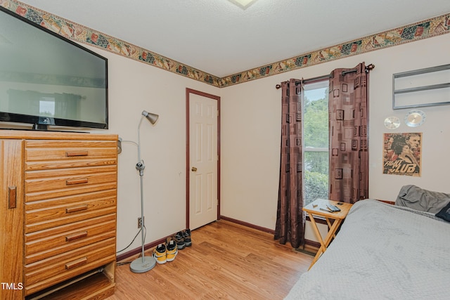 bedroom featuring light wood-style floors and baseboards