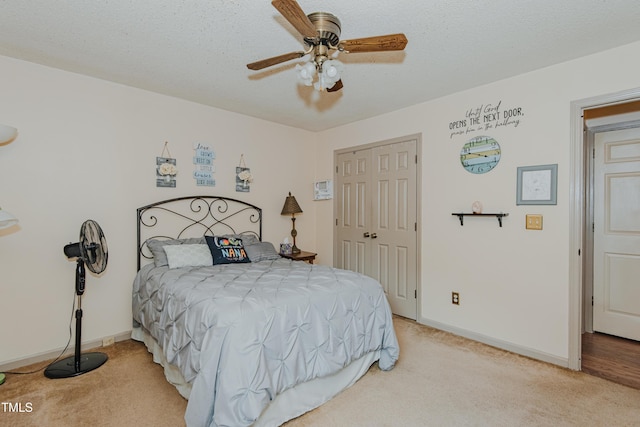 bedroom featuring light carpet, a closet, baseboards, and ceiling fan