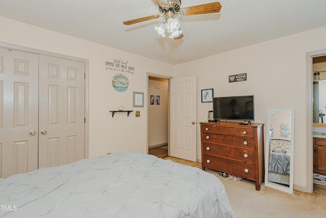 bedroom featuring a closet, light colored carpet, ceiling fan, connected bathroom, and baseboards