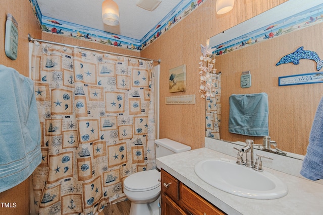 bathroom featuring toilet, vanity, curtained shower, wood finished floors, and wallpapered walls