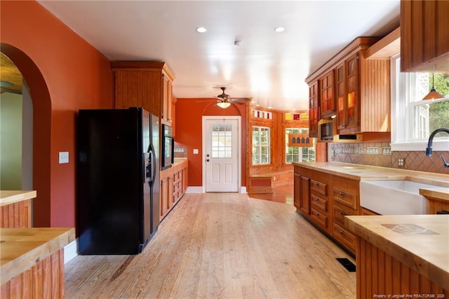 305 N Fayetteville St, Parkton, NC 28371 - kitchen with black appliances, a sink, ceiling fan, arched walkways, and light wood-style flooring