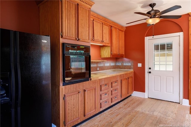 305 N Fayetteville St, Parkton, NC 28371 - kitchen featuring black appliances, a ceiling fan, light wood-style flooring, decorative backsplash, and baseboards