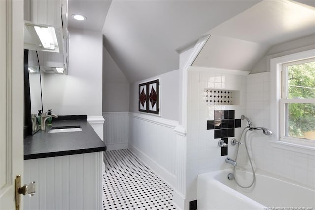 305 N Fayetteville St, Parkton, NC 28371 - bathroom featuring lofted ceiling, a bath, a wainscoted wall, vanity, and tile patterned floors