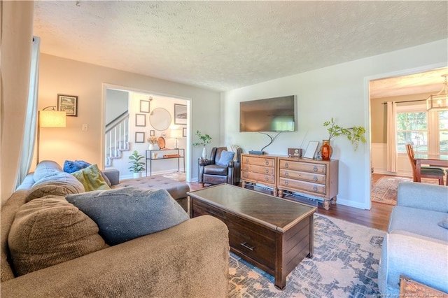 living area featuring stairway, wood finished floors, and a textured ceiling