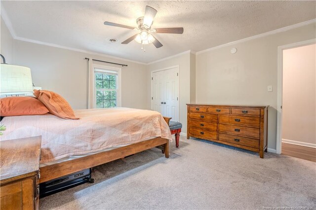 carpeted bedroom with crown molding, baseboards, ceiling fan, and a textured ceiling