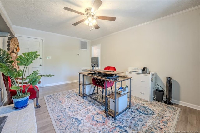 office featuring light wood-style floors, a ceiling fan, baseboards, and ornamental molding