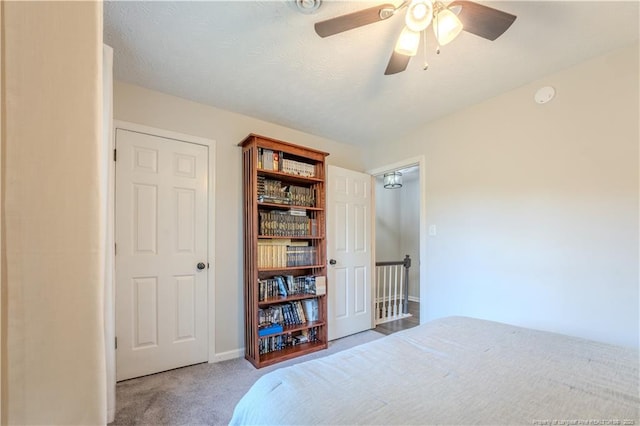 carpeted bedroom featuring baseboards and ceiling fan