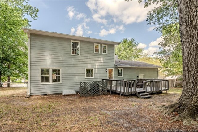 back of house with fence and a deck