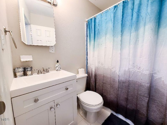 bathroom featuring tile patterned flooring, toilet, vanity, and a shower with curtain