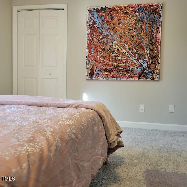 carpeted bedroom featuring baseboards and a closet