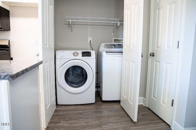 laundry area featuring washing machine and clothes dryer and wood finished floors
