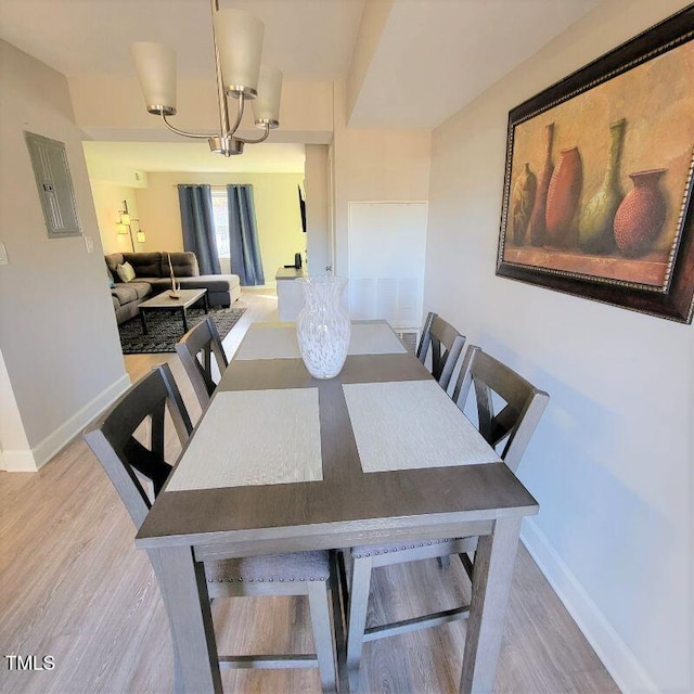 dining room with wood finished floors, baseboards, and a chandelier
