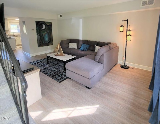 living room featuring light wood-style flooring and baseboards
