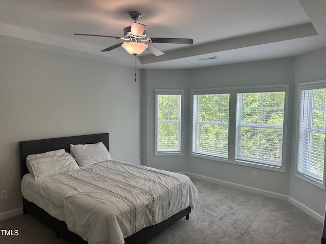 carpeted bedroom with multiple windows, baseboards, and ceiling fan