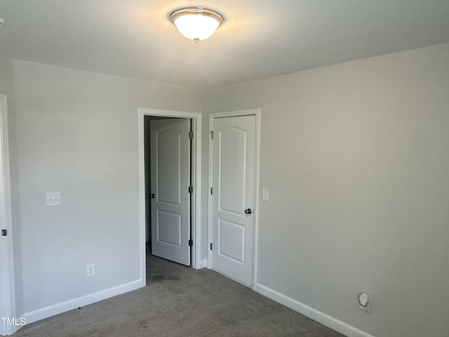 carpeted spare room with baseboards