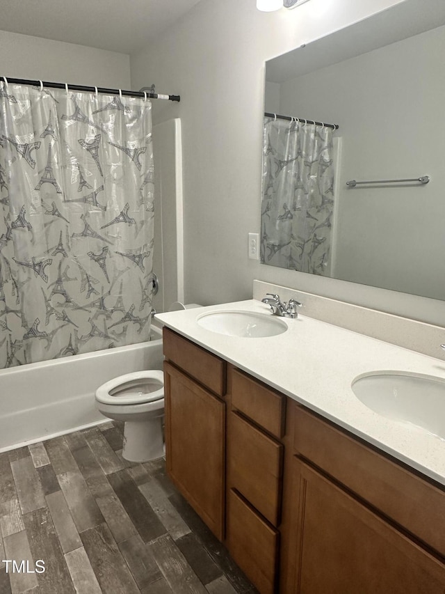bathroom featuring shower / bath combo with shower curtain, double vanity, and toilet