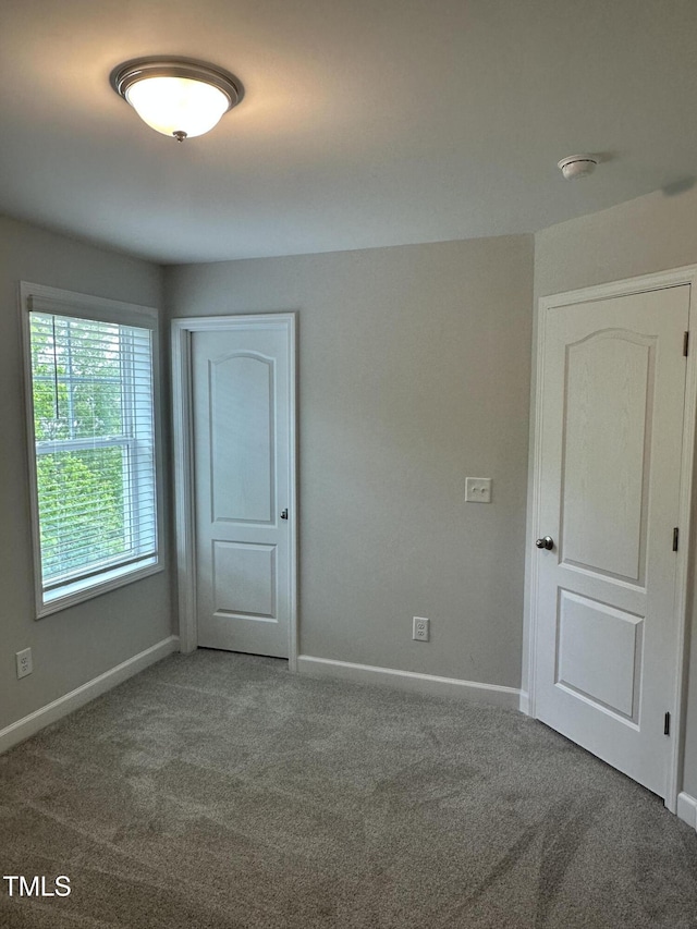 spare room with carpet floors, baseboards, and a smoke detector