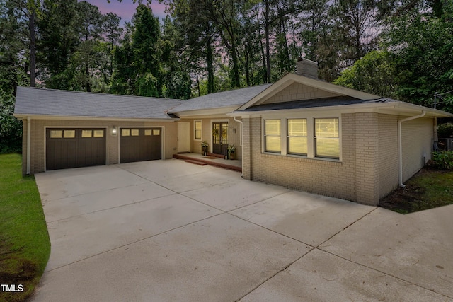 334 Westview Dr, Fayetteville, NC 28303 - view of front facade with a chimney, a garage, driveway, and brick siding