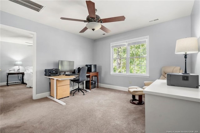 carpeted home office featuring baseboards and ceiling fan