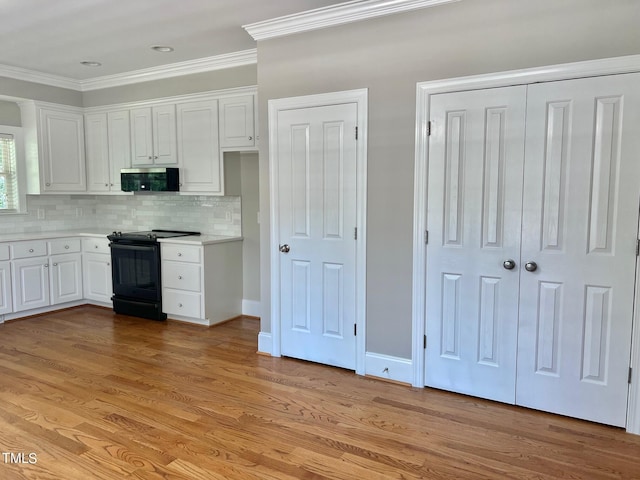 4016 Berman Edge Rd, Holly Springs, NC 27540 - kitchen featuring electric range, stainless steel microwave, white cabinets, ornamental molding, and light countertops