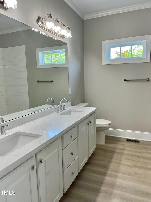 4016 Berman Edge Rd, Holly Springs, NC 27540 - full bathroom with wood finished floors, ornamental molding, plenty of natural light, toilet, and double vanity