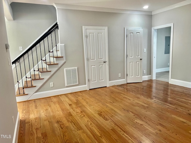 4016 Berman Edge Rd, Holly Springs, NC 27540 - unfurnished living room featuring ornamental molding, electric panel, wood finished floors, stairs, and baseboards