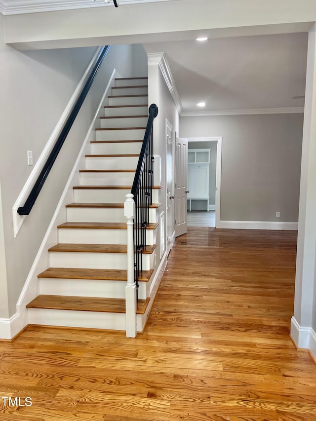 4016 Berman Edge Rd, Holly Springs, NC 27540 - stairway with crown molding, baseboards, wood finished floors, and recessed lighting