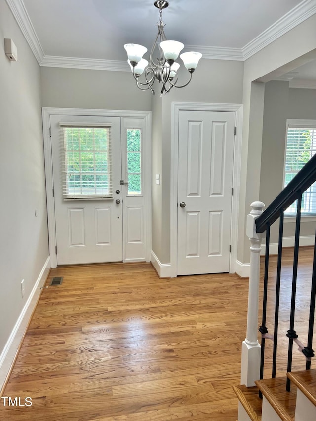 4016 Berman Edge Rd, Holly Springs, NC 27540 - foyer entrance with light wood-style flooring, a chandelier, crown molding, baseboards, and stairs