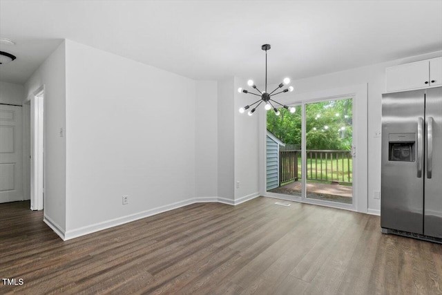 unfurnished dining area with dark wood-style flooring, a chandelier, and baseboards