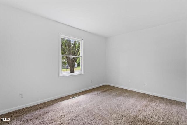 empty room featuring carpet floors and baseboards