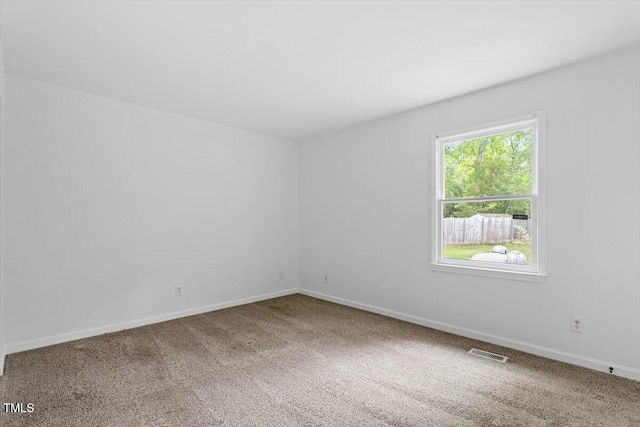 unfurnished room with carpet flooring and baseboards