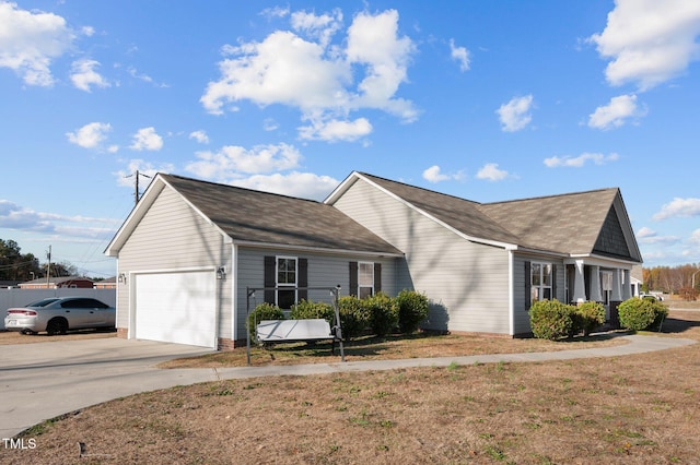 view of front of house featuring a garage, driveway, and roof with shingles