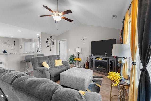 living room with wood finished floors, a ceiling fan, vaulted ceiling, and recessed lighting
