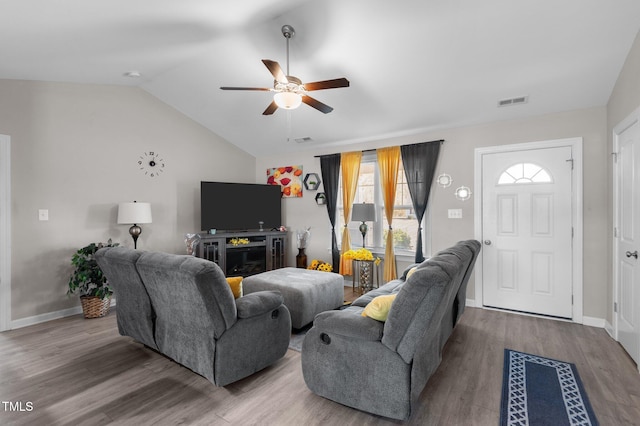 living room featuring ceiling fan, lofted ceiling, wood finished floors, and baseboards