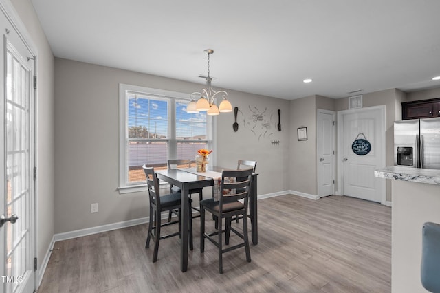 dining space featuring light wood-style flooring, a chandelier, baseboards, and recessed lighting