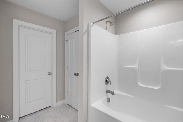 bathroom with tile patterned floors, shower / washtub combination, and baseboards