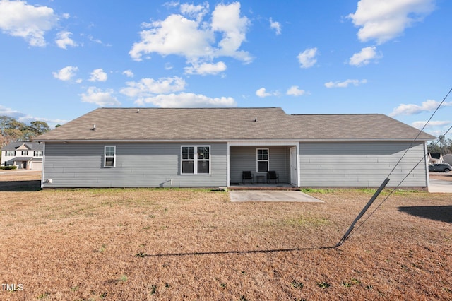 back of house featuring a patio area, a yard, and a shingled roof