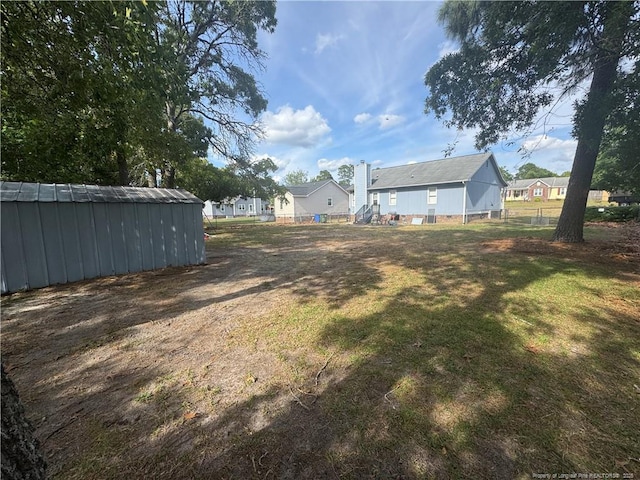 view of green lawn with an outbuilding and a residential view