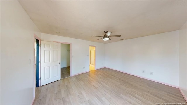 2500 Forest Lodge Dr, Fayetteville, NC 28306 - unfurnished bedroom with baseboards, light wood-type flooring, a ceiling fan, and a spacious closet