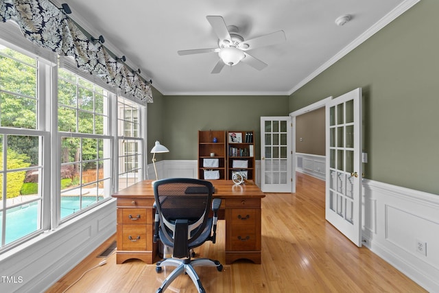 office area with wainscoting, french doors, healthy amount of natural light, a ceiling fan, and ornamental molding