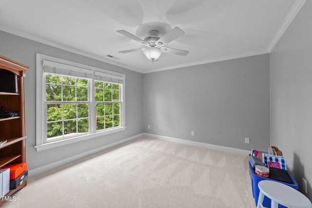 spare room featuring carpet, baseboards, crown molding, and a ceiling fan