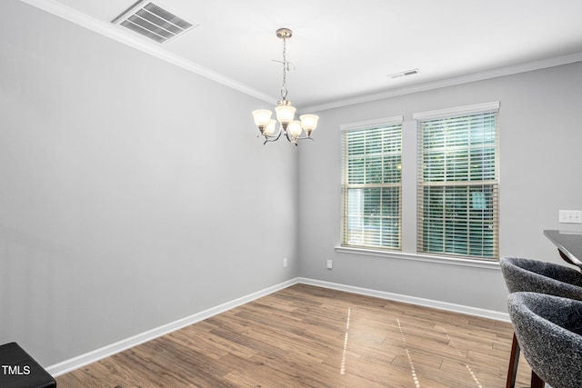 living area with a chandelier, wood finished floors, ornamental molding, and baseboards