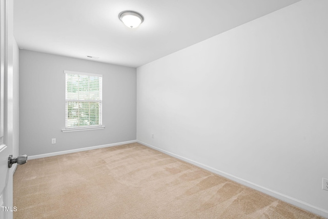 carpeted spare room featuring baseboards