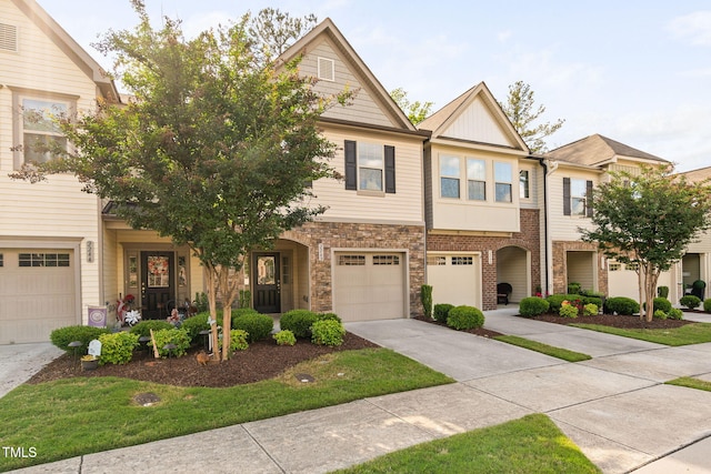 townhome / multi-family property with driveway, an attached garage, and stone siding