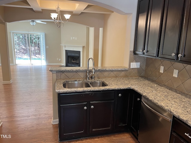kitchen featuring stainless steel dishwasher, a sink, a peninsula, open floor plan, and ceiling fan