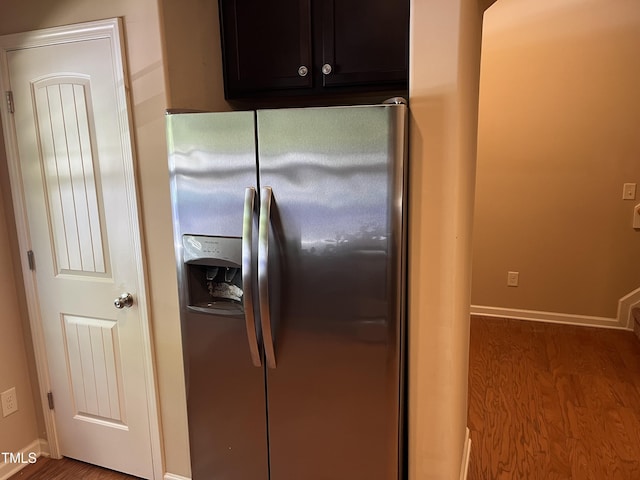 kitchen with stainless steel refrigerator with ice dispenser, wood finished floors, and baseboards