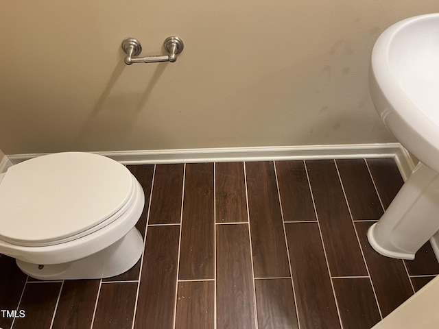 bathroom with wood tiled floors and toilet